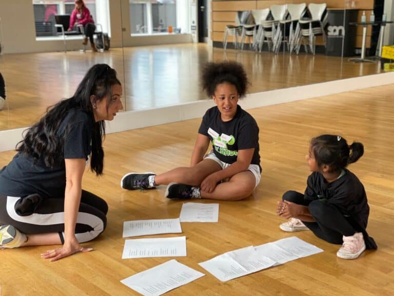 learners sitting on the floor completing thier worksheets